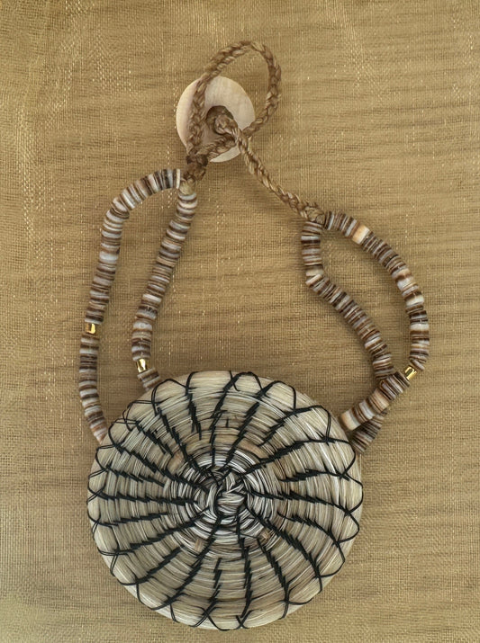 White woven horsehair bracelet with dark radial stitching and a braided button closure