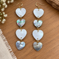 Cascading earrings with alternating pale and dark shell hearts