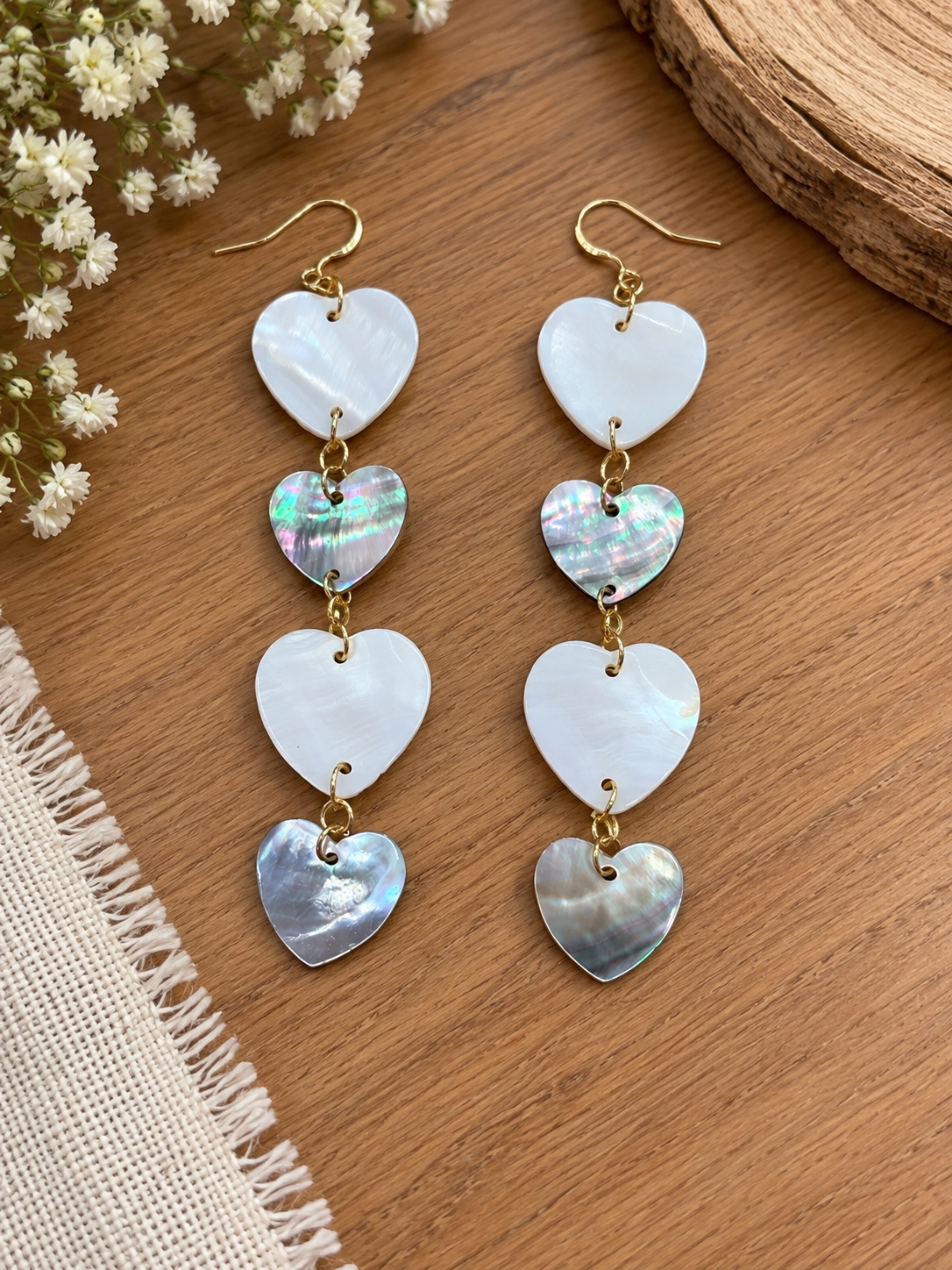 Cascading earrings with alternating pale and dark shell hearts