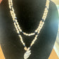 Shell and blue-bead necklace with a wrapped arrowhead-shaped pendant