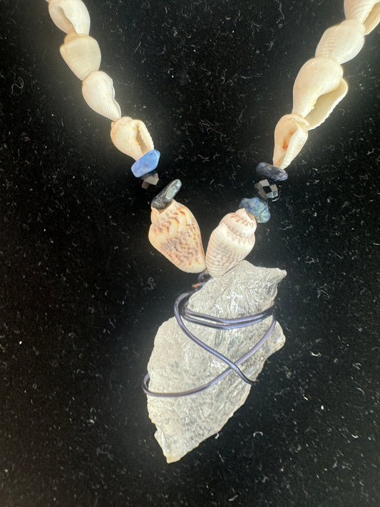 Close-up of shell beads, blue accents, and the wrapped pendant