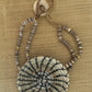 White woven horsehair bracelet with dark radial stitching and a braided button closure