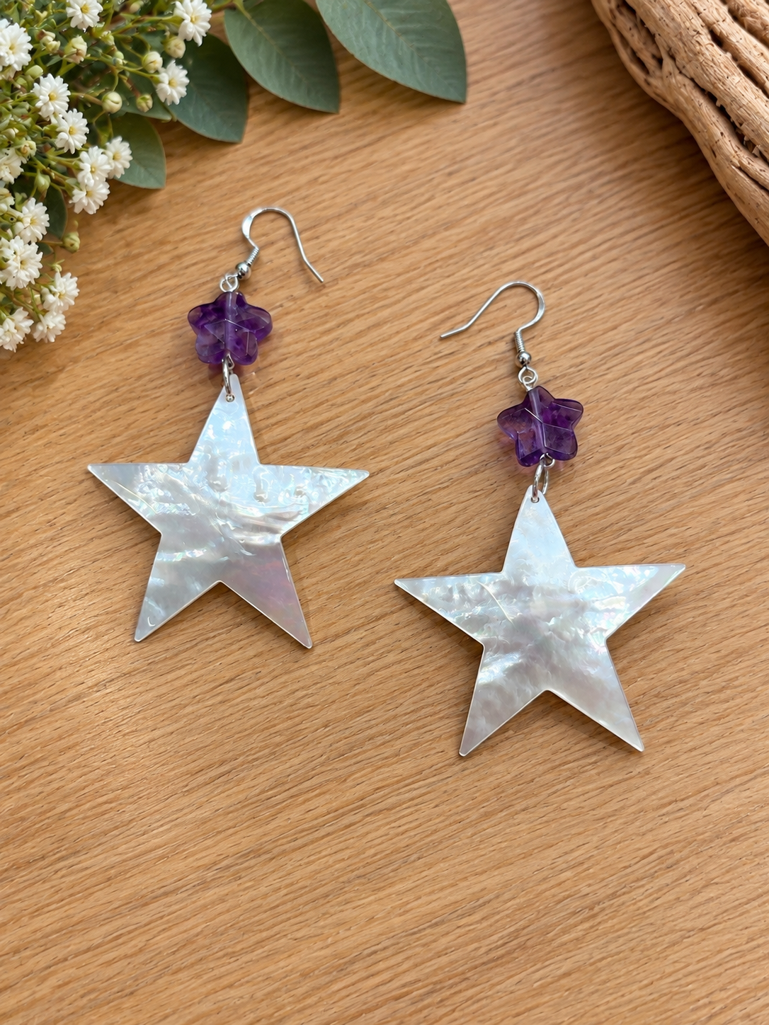 Mother-of-pearl star earrings with small purple flower accents