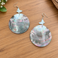 Round black lip shell earrings with small pale butterfly accents