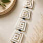 Close-up of square spiral-design mother-of-pearl earrings
