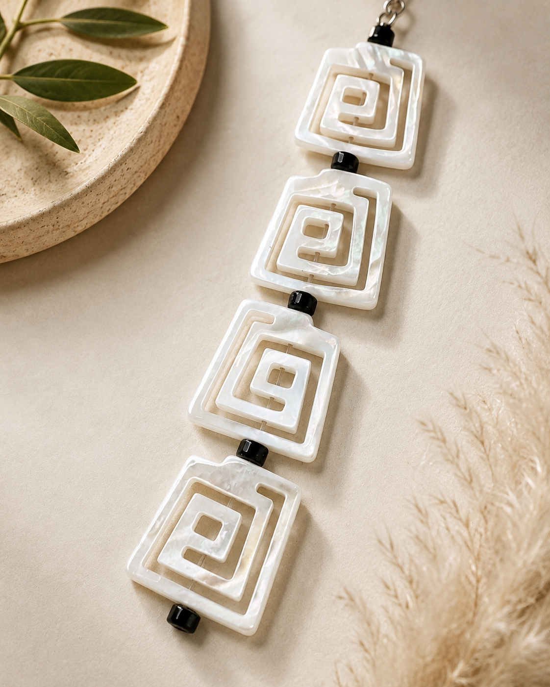 Close-up of square spiral-design mother-of-pearl earrings