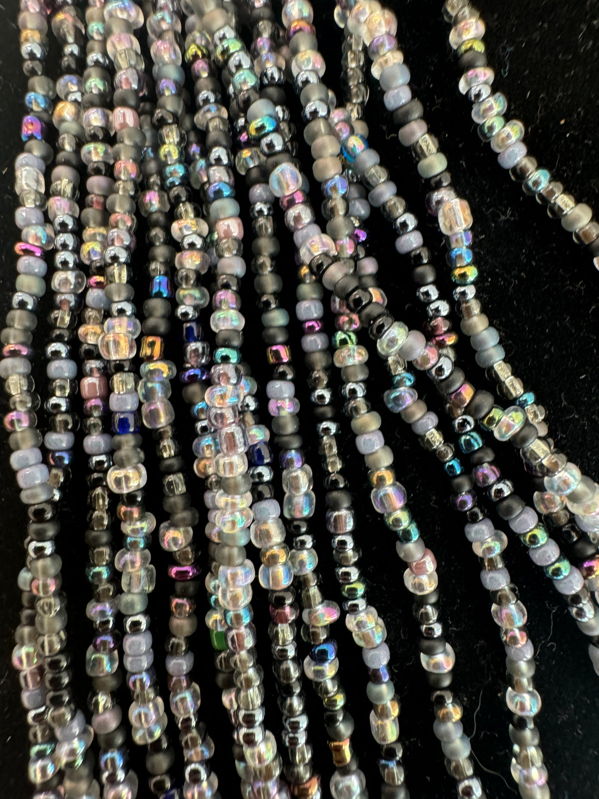 Close-up of gray and iridescent seed-bead strands