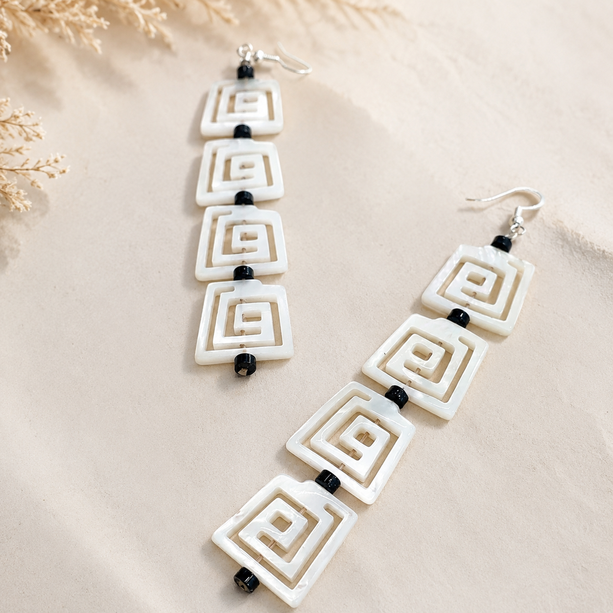 Long mother-of-pearl earrings with four square spiral-design drops