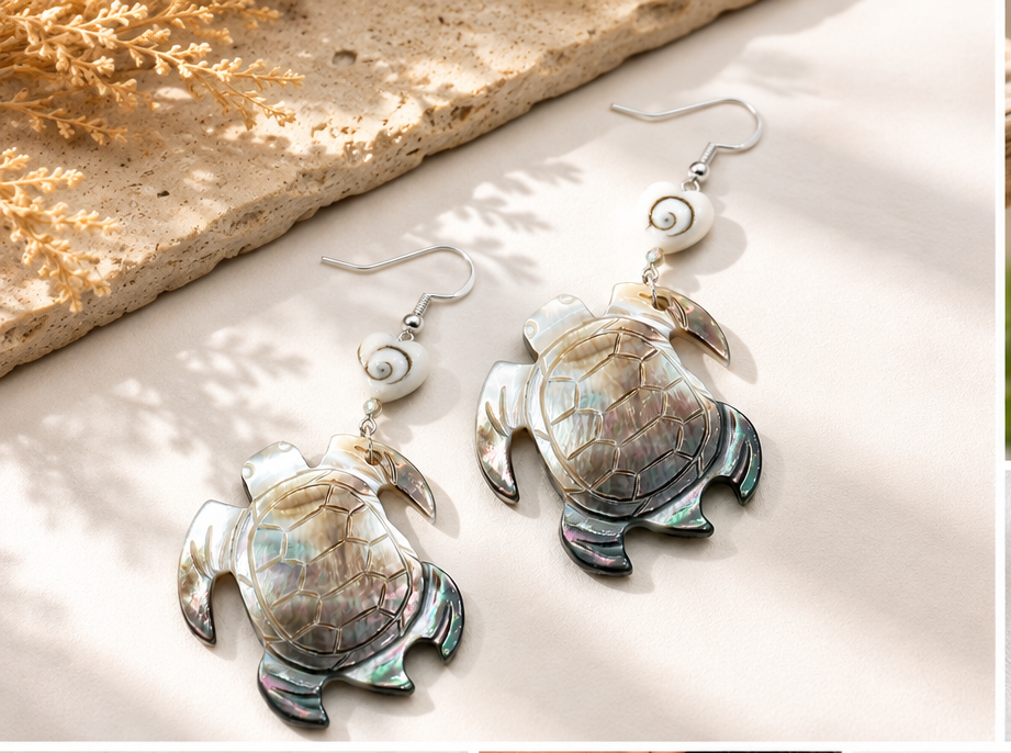 Turtle-shaped shell earrings arranged on fabric