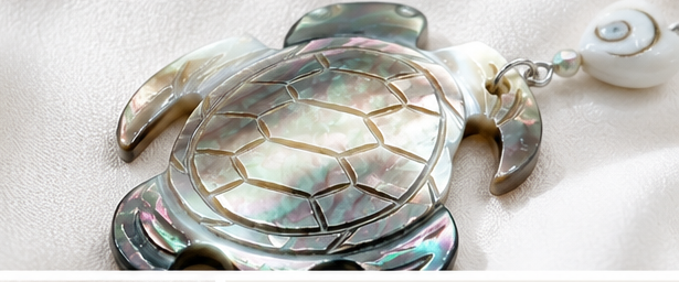 Close-up of turtle-shaped shell earrings and carved shell details